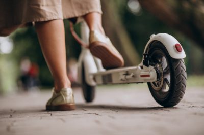 v-mujer-joven-equitacion-patineta-estacionamiento-pies-cicatrizarse_1303-15755